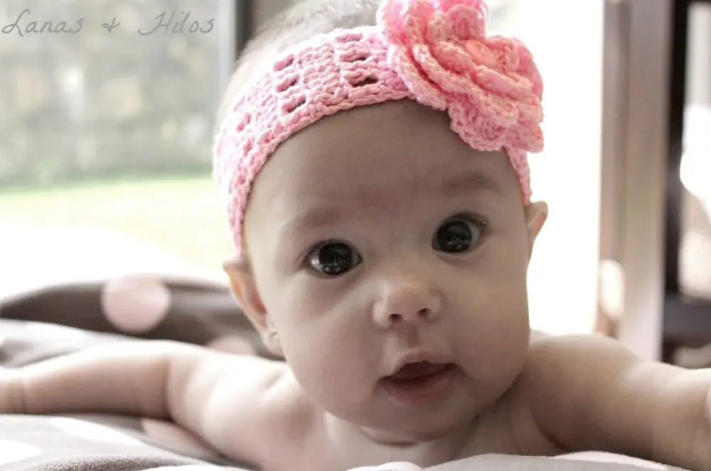 image of baby with a pink crocheted headband with a flower