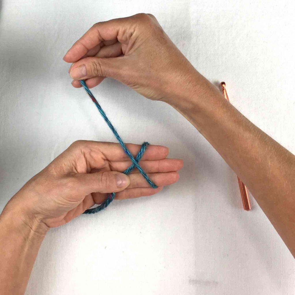 image of green yarn looped around a hand
