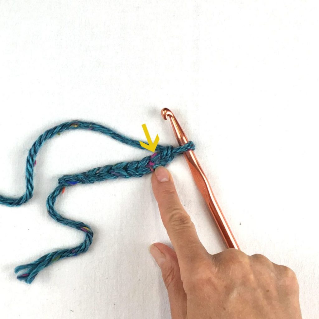 image of a crochet chain and hand showing where to insert hook