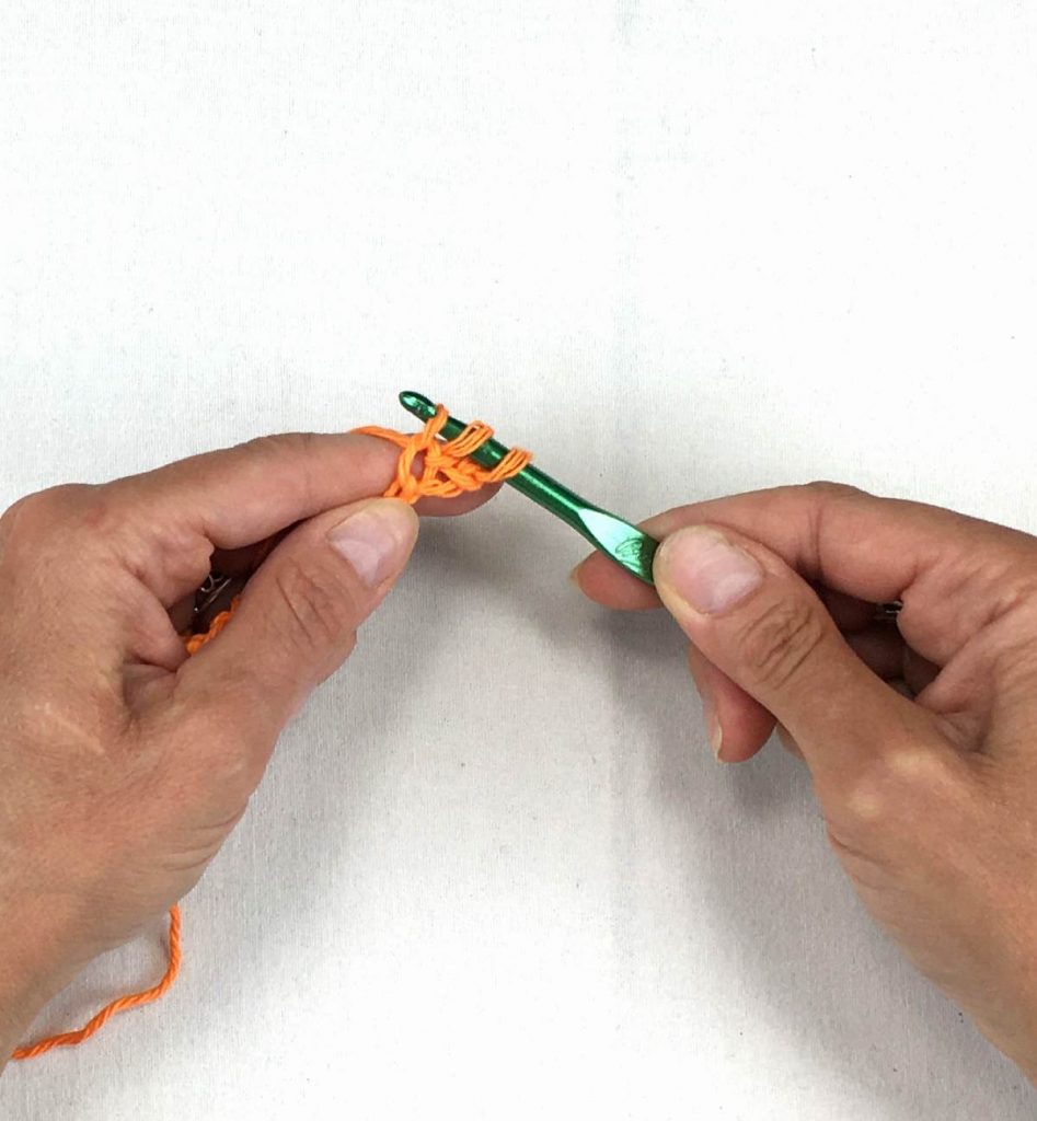 pulling the yarn through the chain stitch