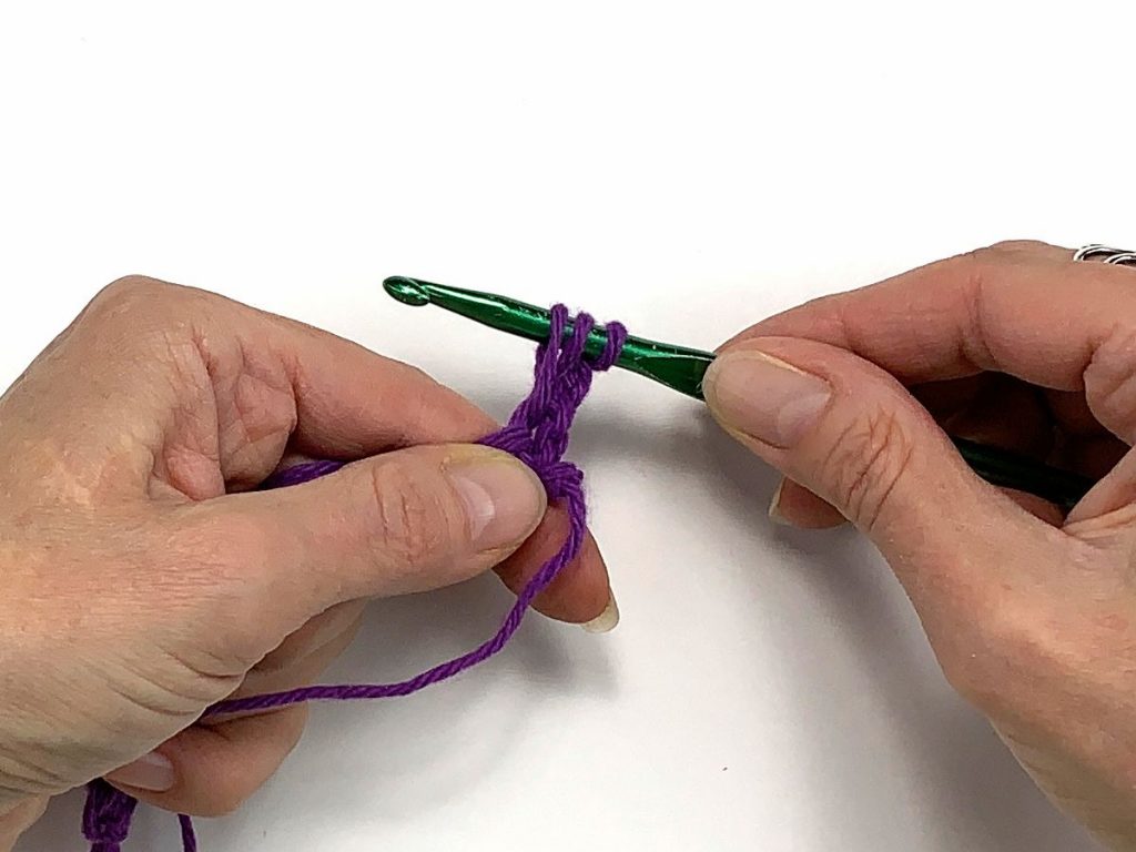 a crochet hook with three loops of yarn