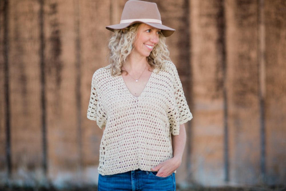 image of a woman wearing a tan hat and a crochet top
