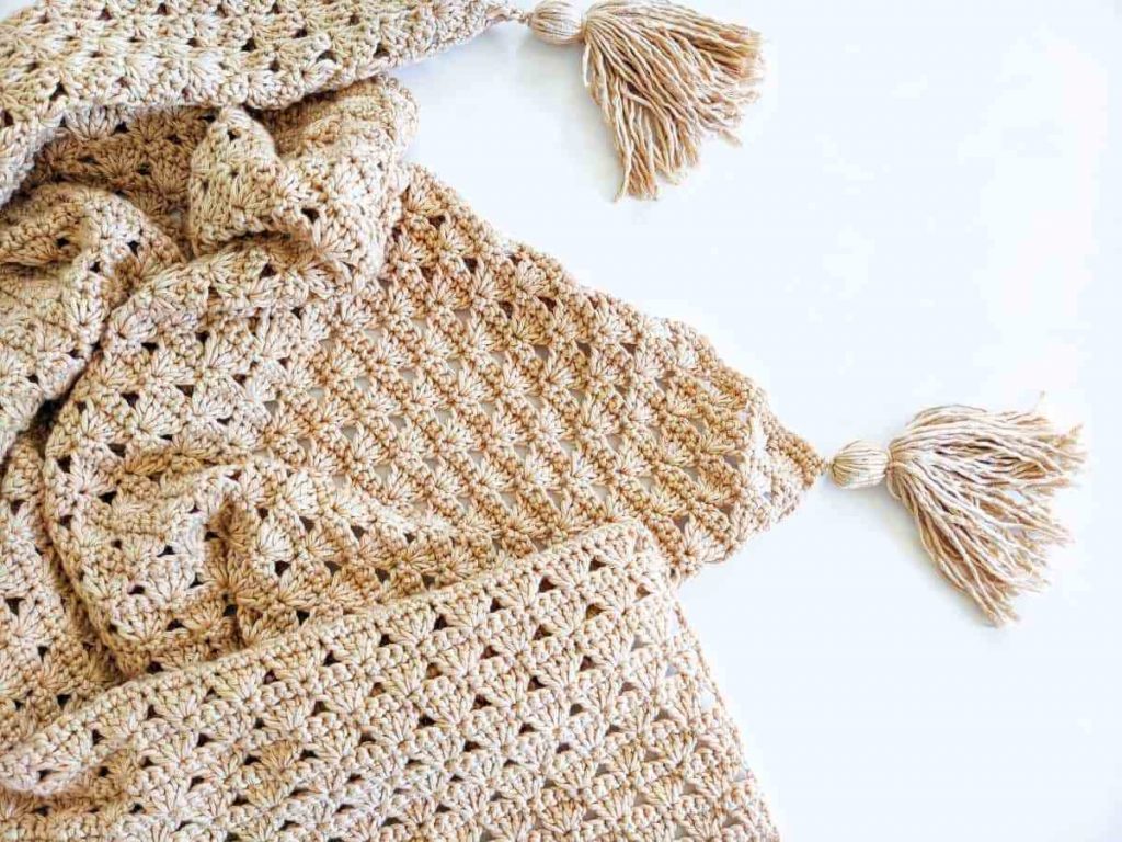 image of a tan crocheted blanket with tassels