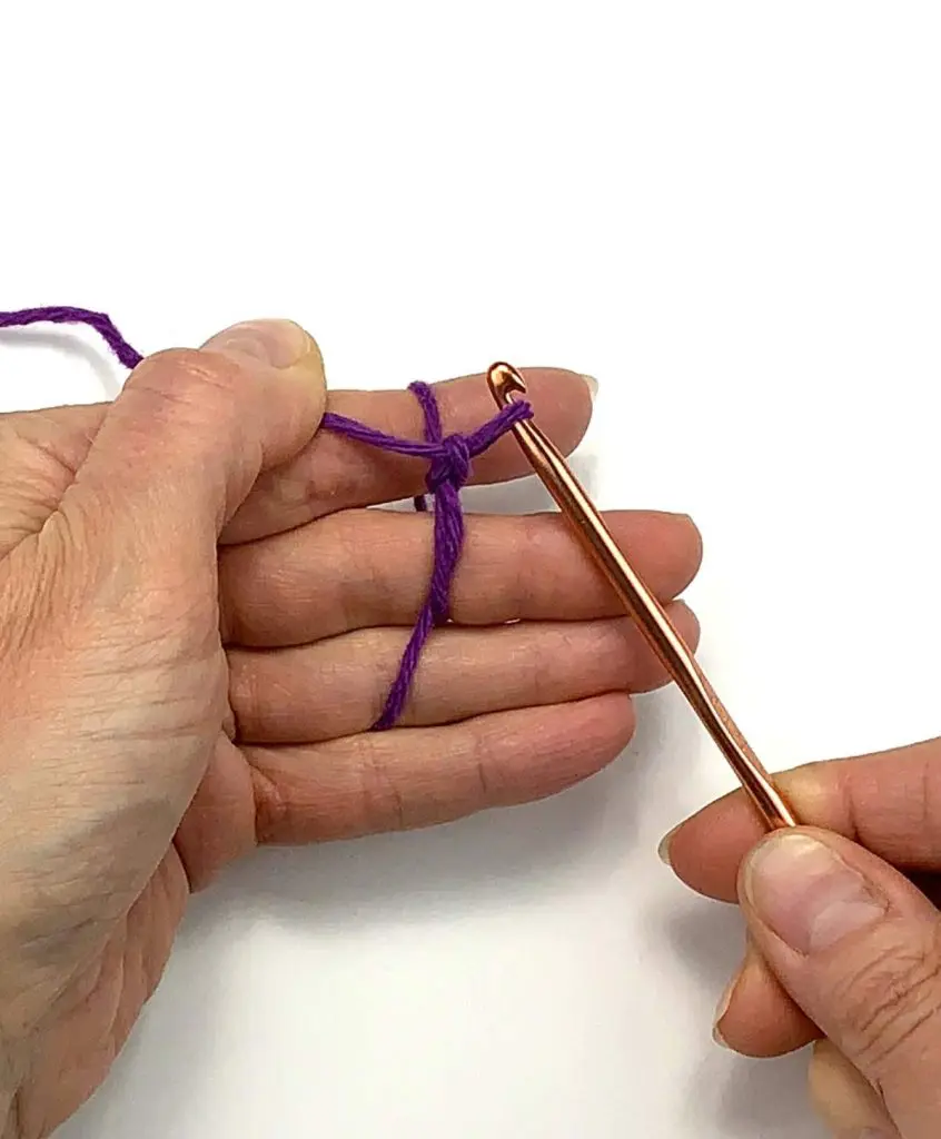 image of hands making a slip knot with a crochet hook 