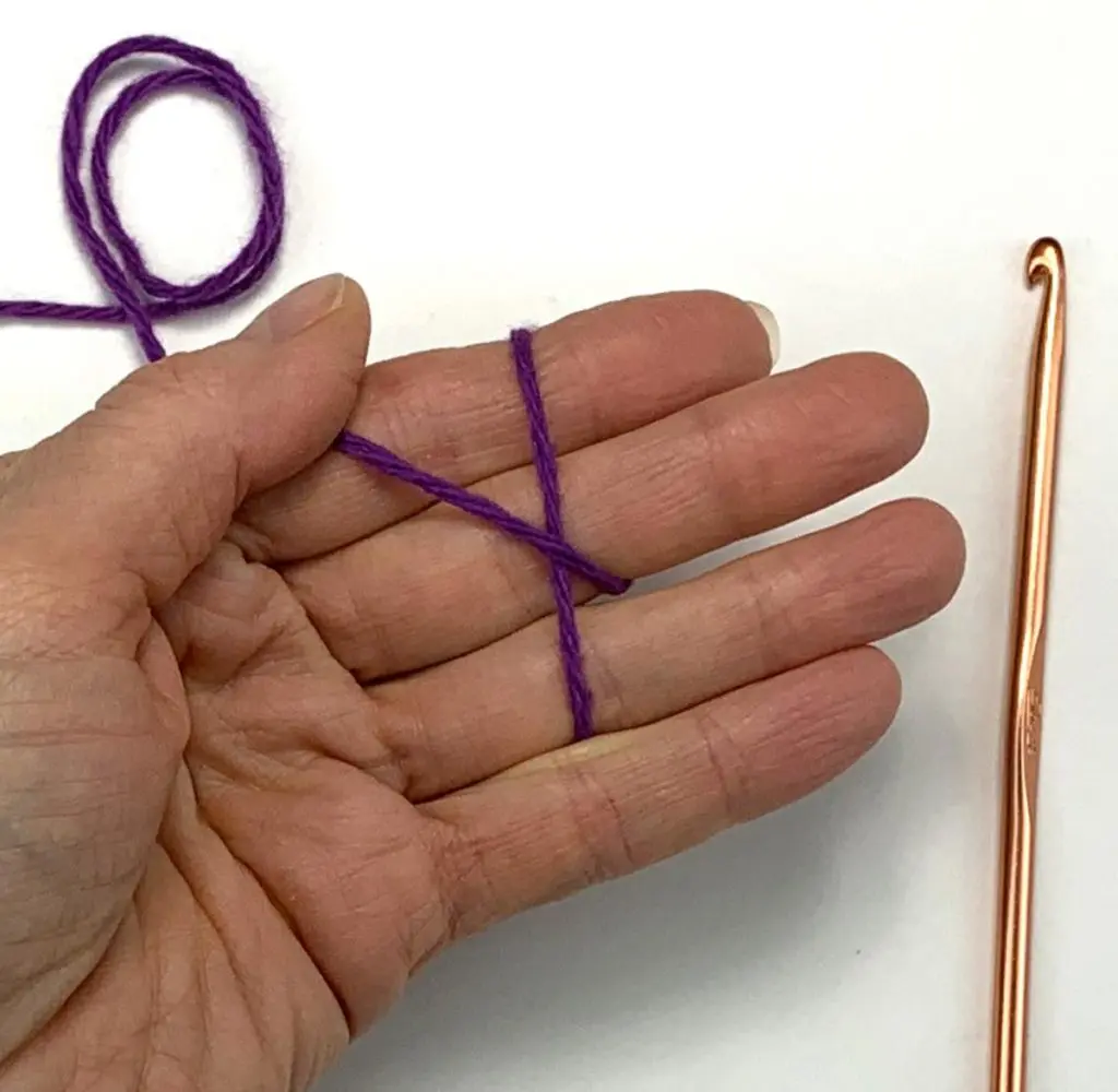 a hand holding a strand of yarn