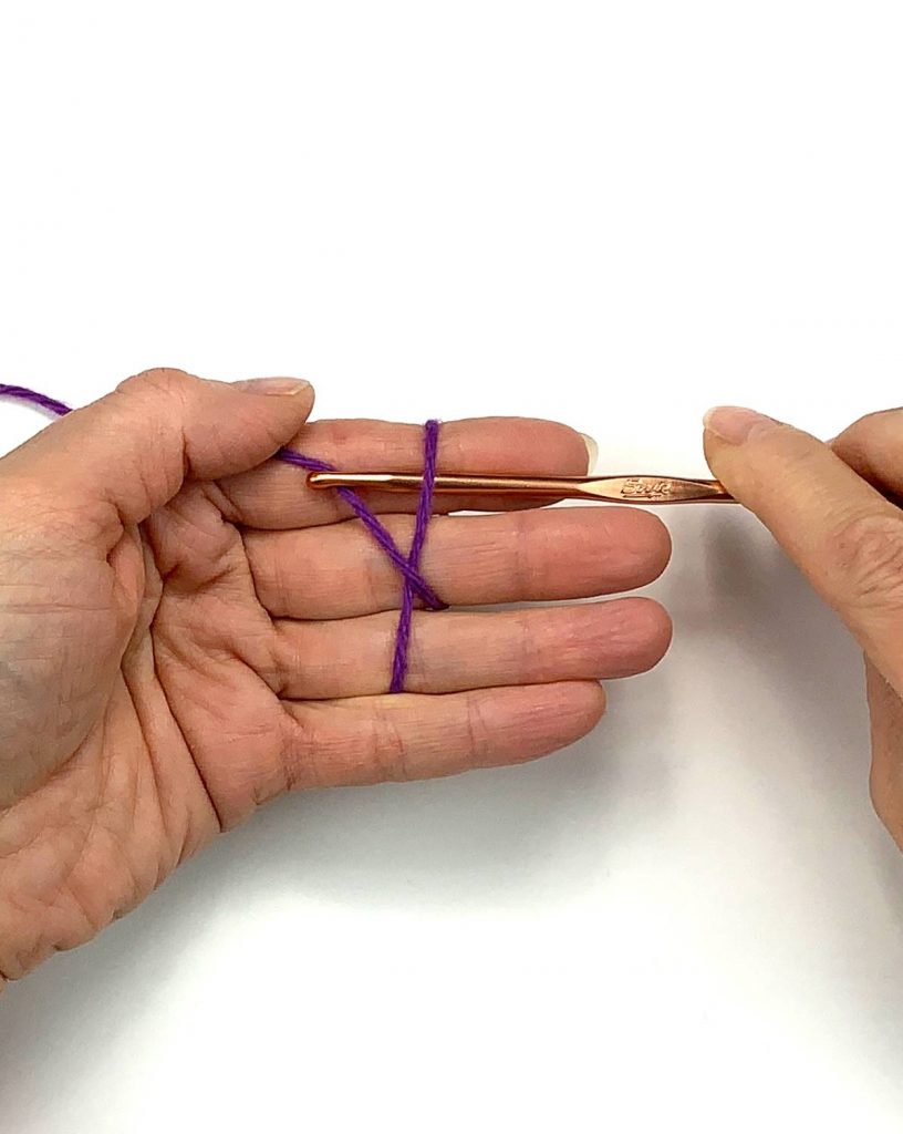 image of hand grabbing yarn with a crochet hook
