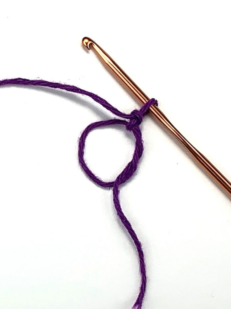 image of a circle with purple yarn and a crochet hook