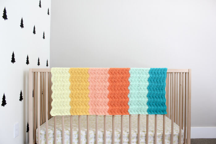 image of a striped crochet blanket on a baby crib