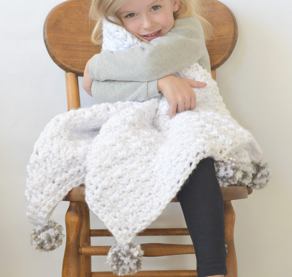 image of a girl sitting on a chair holding a white blanket