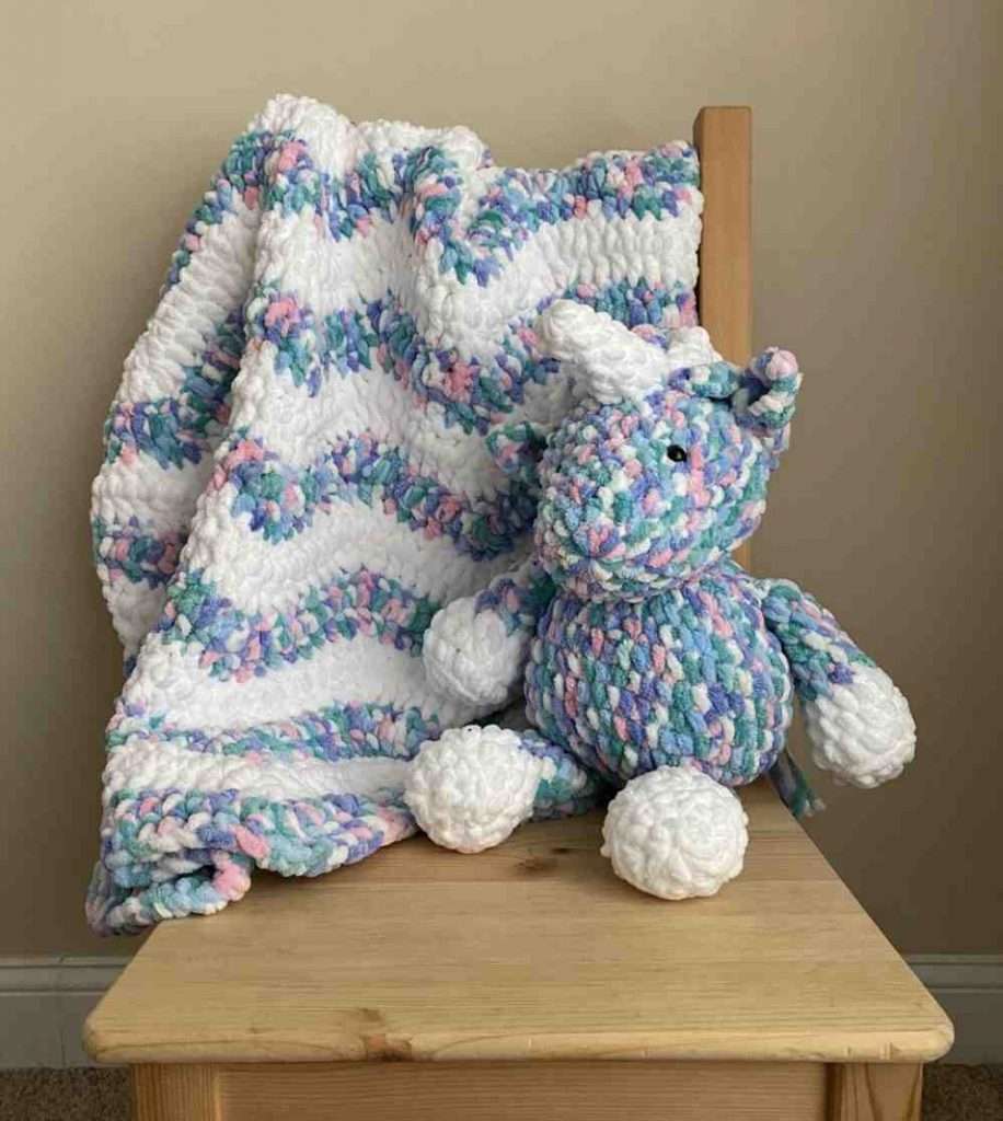 image of a striped crochet blanket and teddy bear