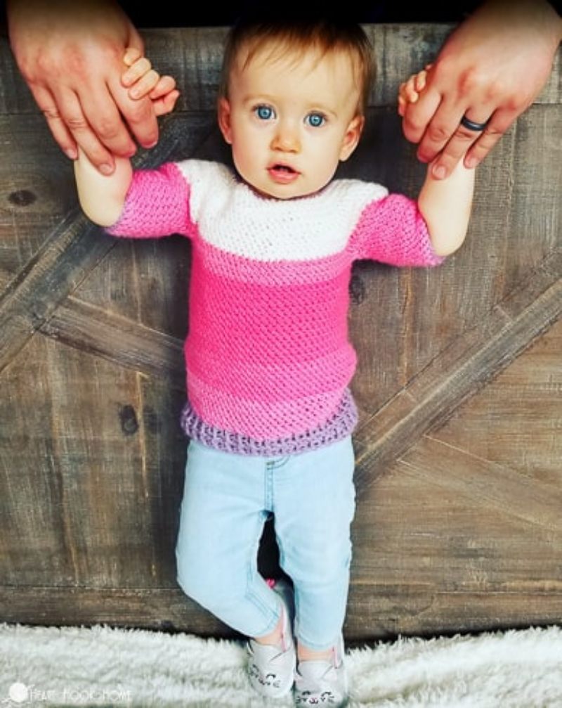 image of a baby with a pink and white sweater