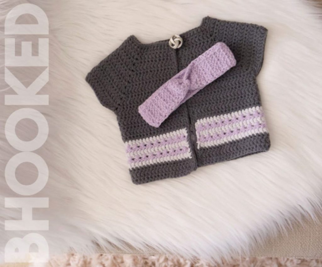 image of a brown and lavender crochet sweater and headband on a fur rug