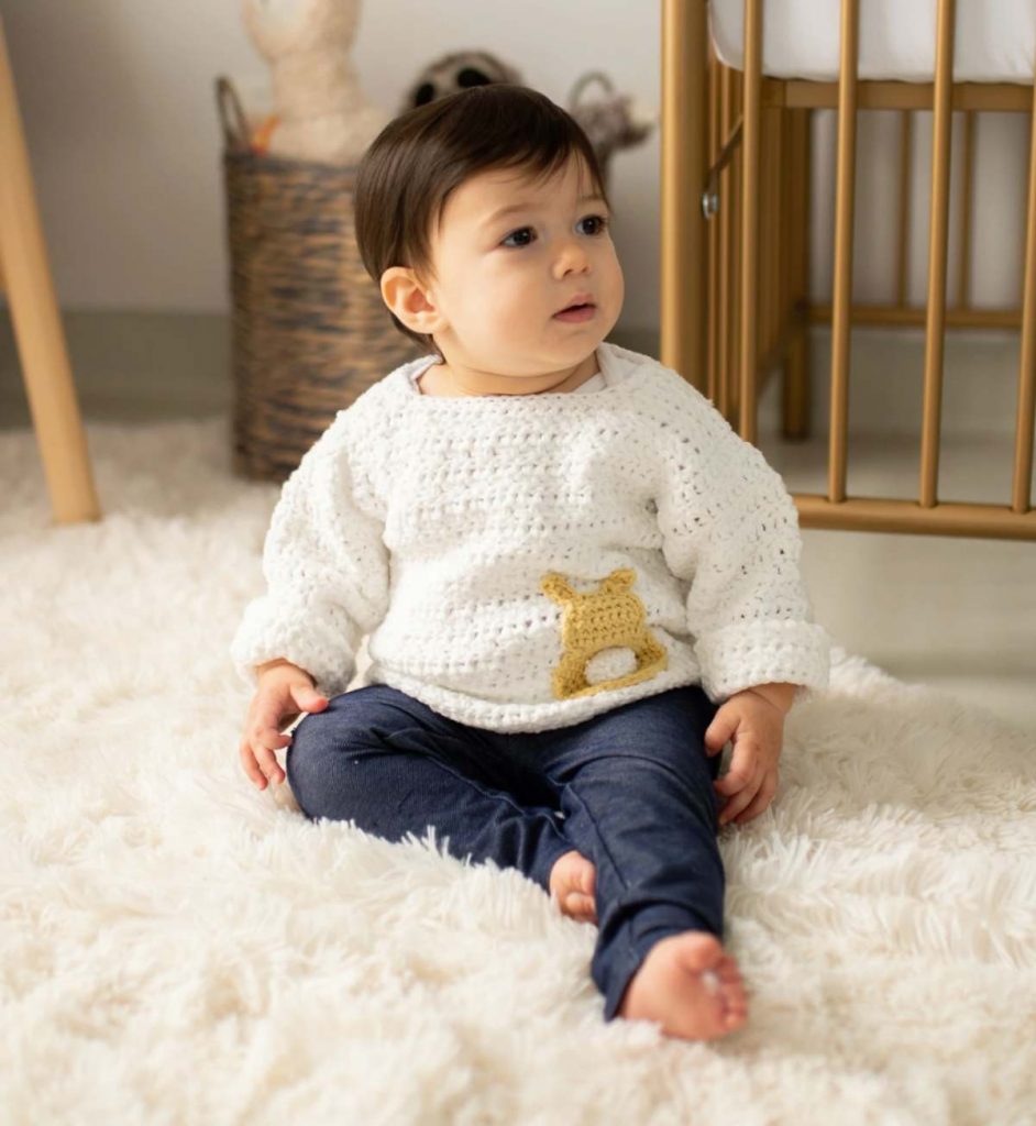 image of a baby boy with a white sweater and jeans