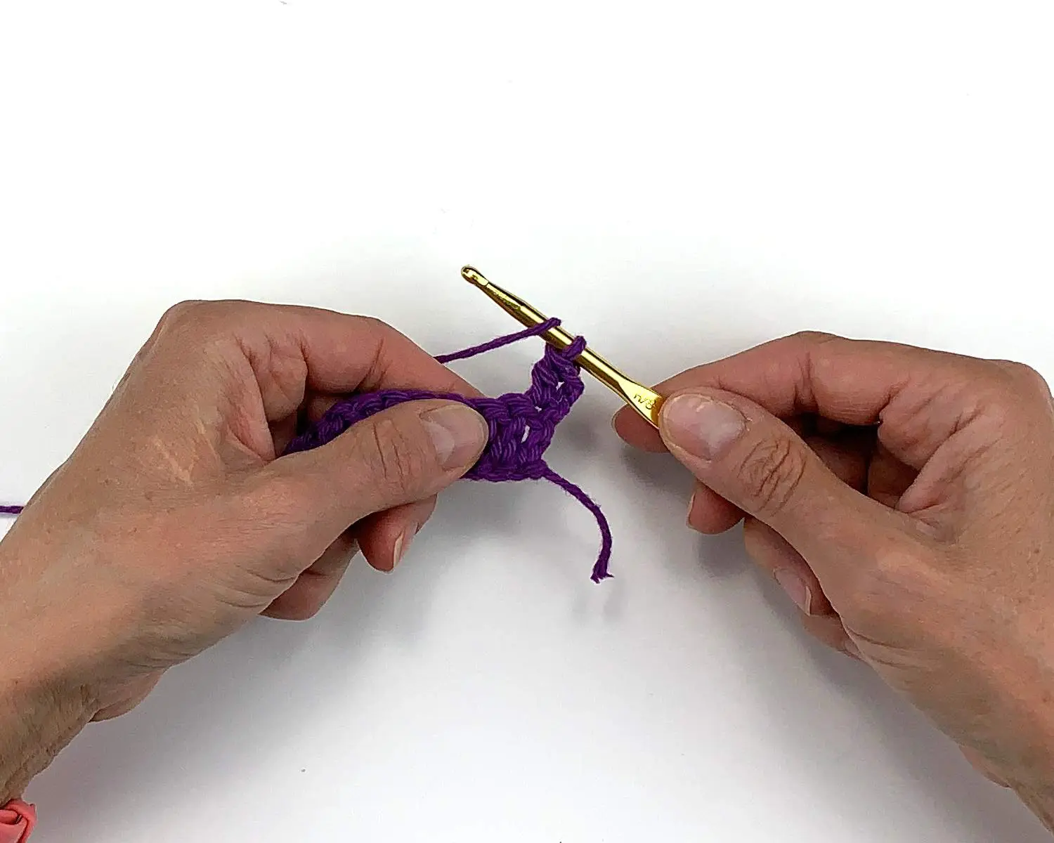 image of hands making a crochet yarn over