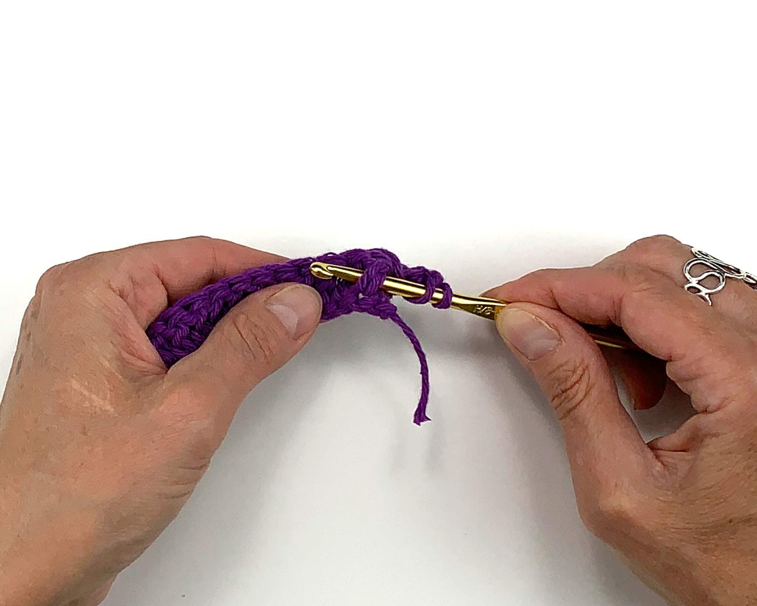 image of hands moving crochet hook under a double stitch