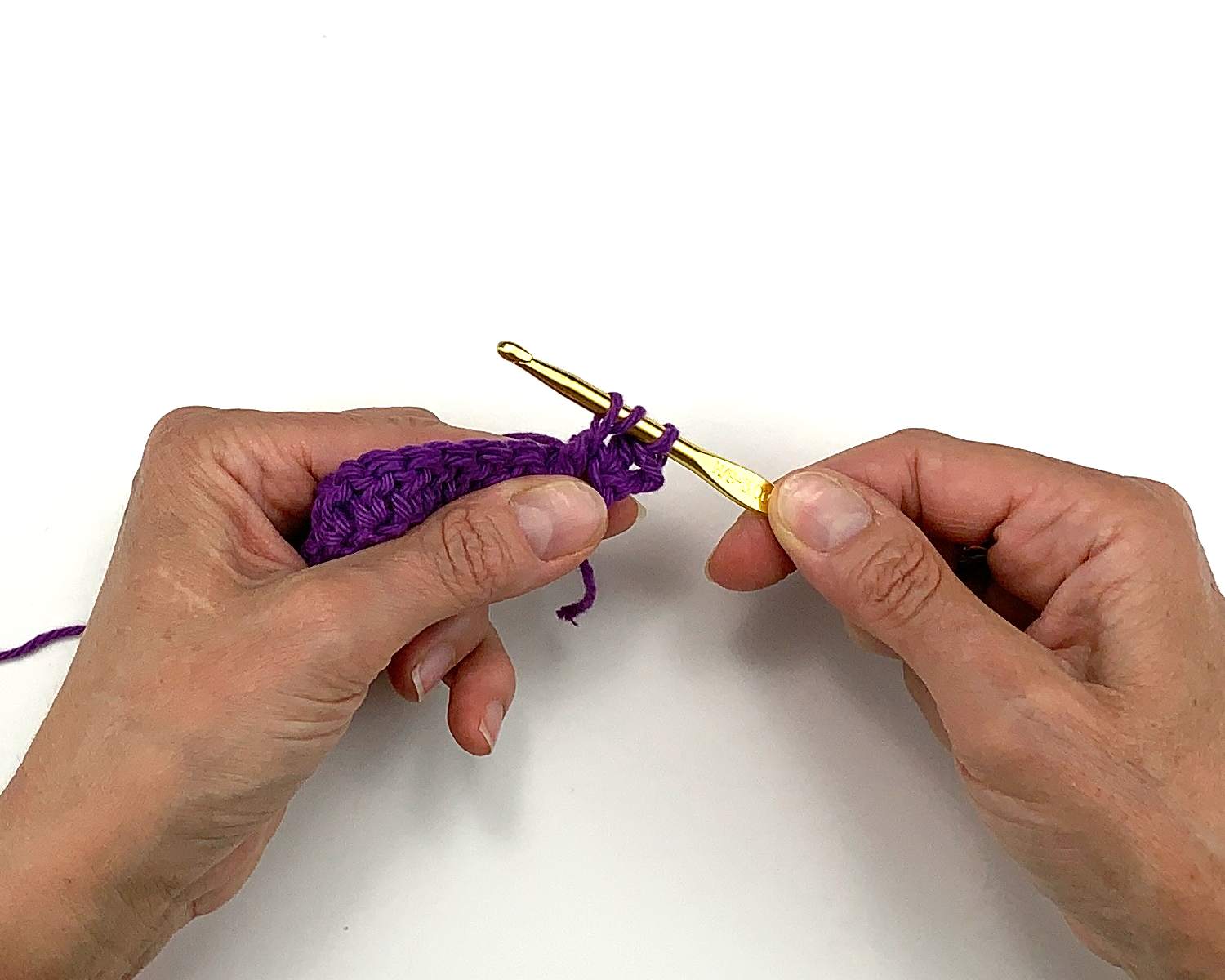 image of hands holding crochet work and a hook