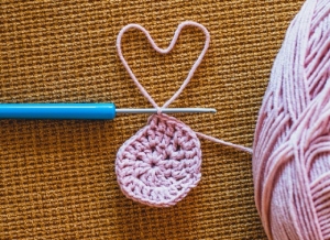 image of round crochet work with pink yarn